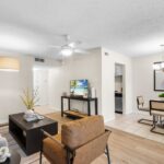 One-Bedroom Apartments in Winter Park, FL - The Taylor - Living Room with Atrium Entries, Ceiling Fan, Ceramic Tile Flooring, and Wood Style Flooring