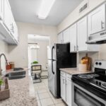 Apartments in Winter Park, FL for Rent - The Taylor - Kitchen with Stainless Steel Appliances, Ceramic Tile Flooring, and White Cabinets